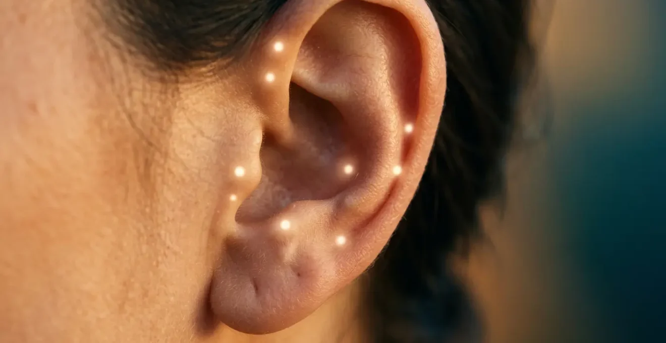 Vista detallada de una oreja con puntos luminosos de auriculoterapia para dejar de fumar