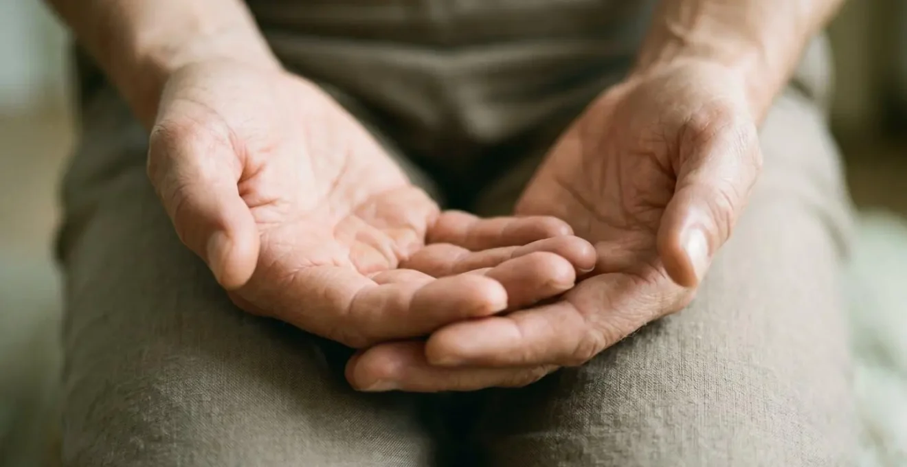Primer plano de manos en reposo sobre las rodillas en posición meditativa